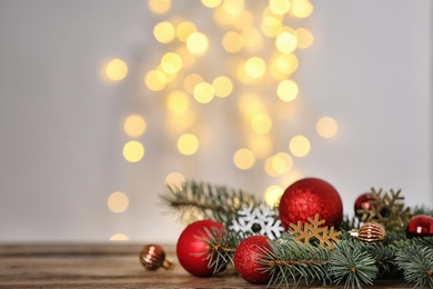 Photo of Christmas decoration on table against blurred lights. Space for text