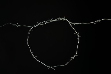 Shiny metal barbed wire on black background