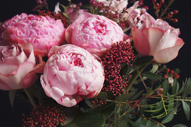 Photo of Beautiful fresh bouquet on dark background, closeup. Floral decor