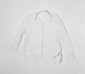 Crumpled shirt on white background, top view