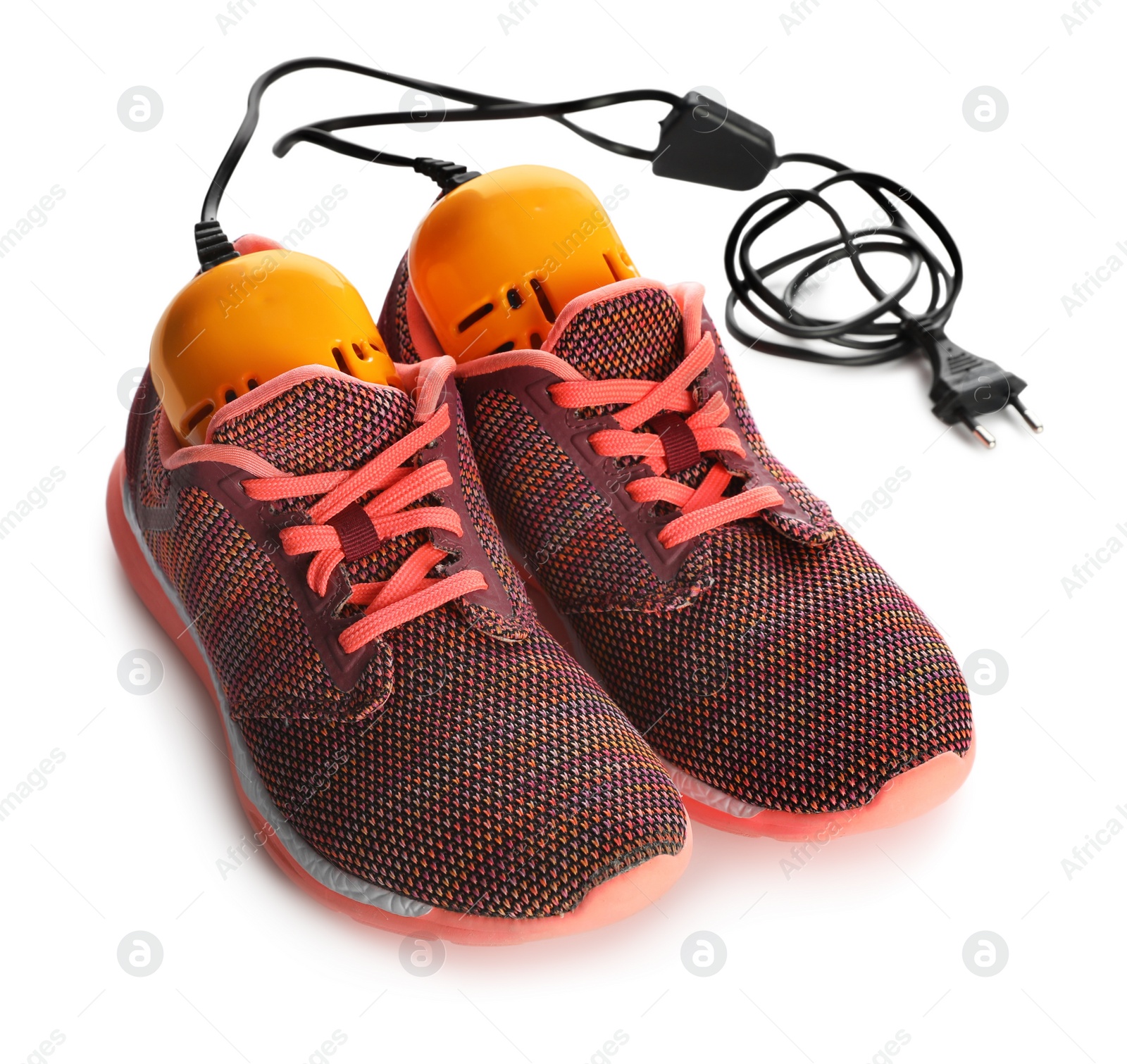 Photo of Pair of stylish sneakers with modern electric shoe dryer on white background