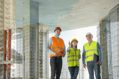 Image of Double exposure of engineers at construction site and modern buildings