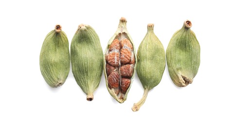 Photo of Dry green cardamom pods on white background, top view