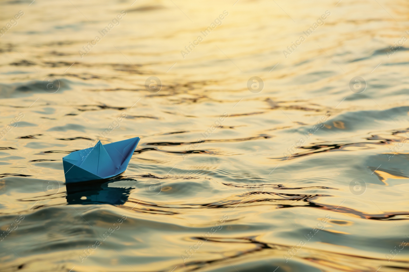 Photo of Paper boat floating on water outdoors. Space for text