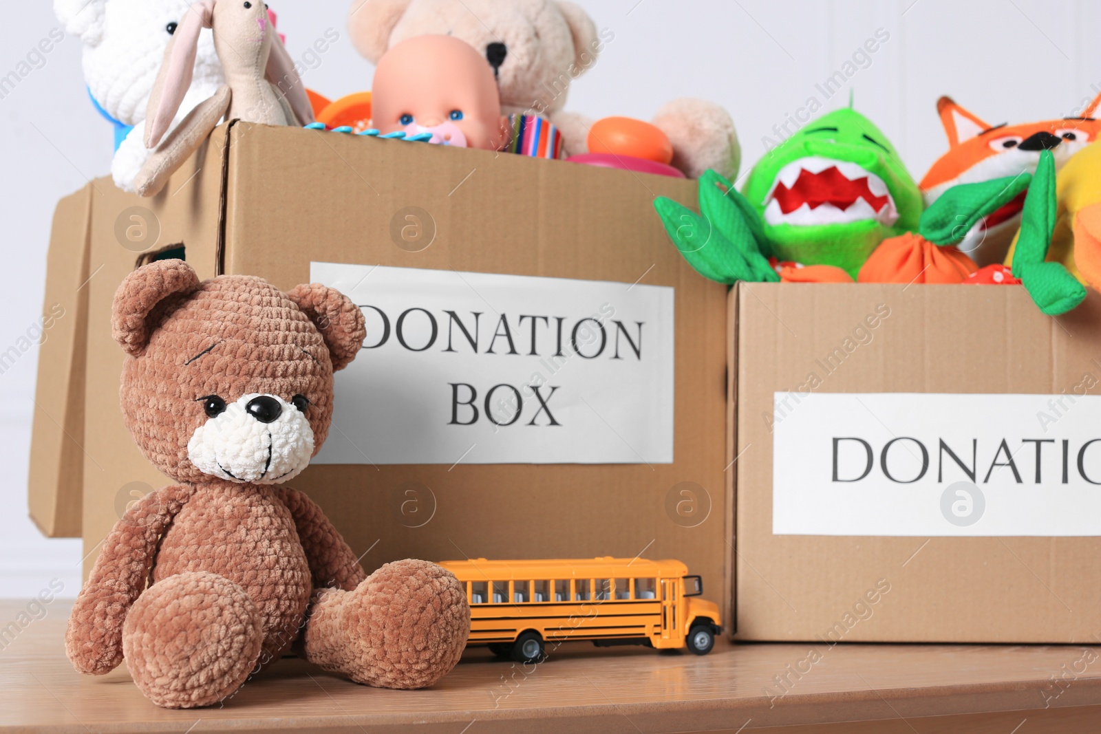Photo of Donation boxes and different child toys on wooden table