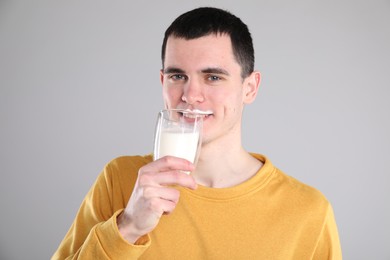 Photo of Milk mustache left after dairy product. Man drinking milk on gray background