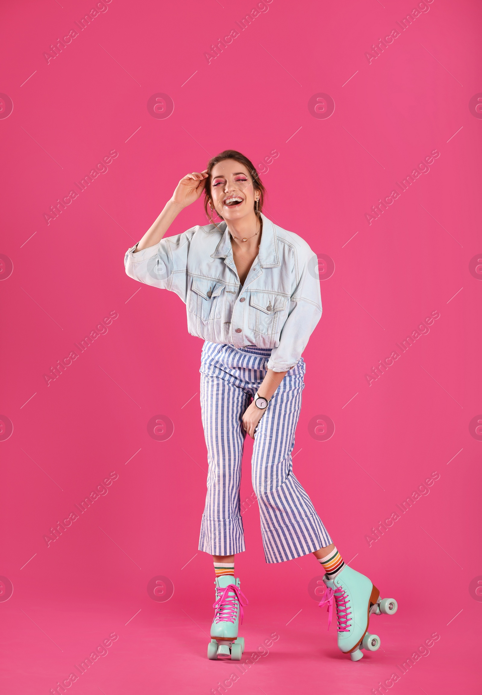 Photo of Young woman with retro roller skates on color background