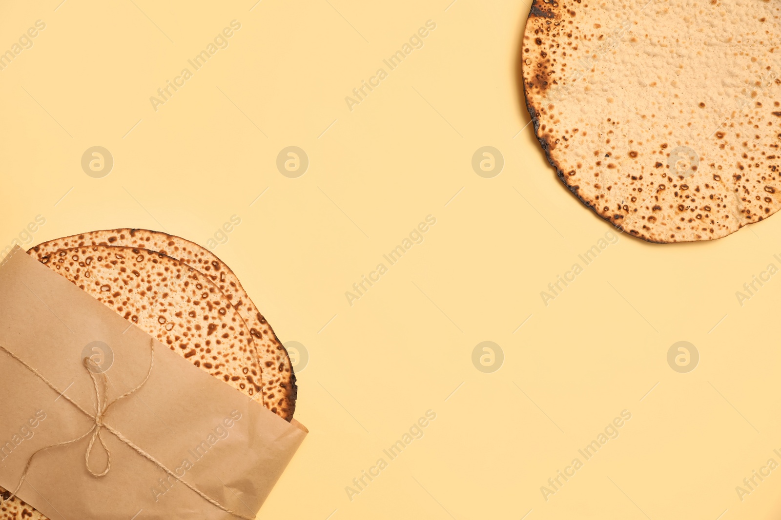 Photo of Tasty matzos on beige background, flat lay with space for text. Passover (Pesach) celebration