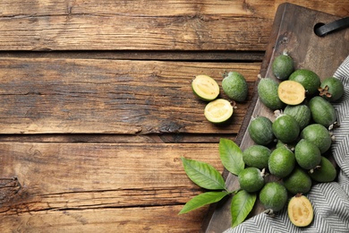 Flat lay composition with fresh green feijoa fruits on wooden table, space for text