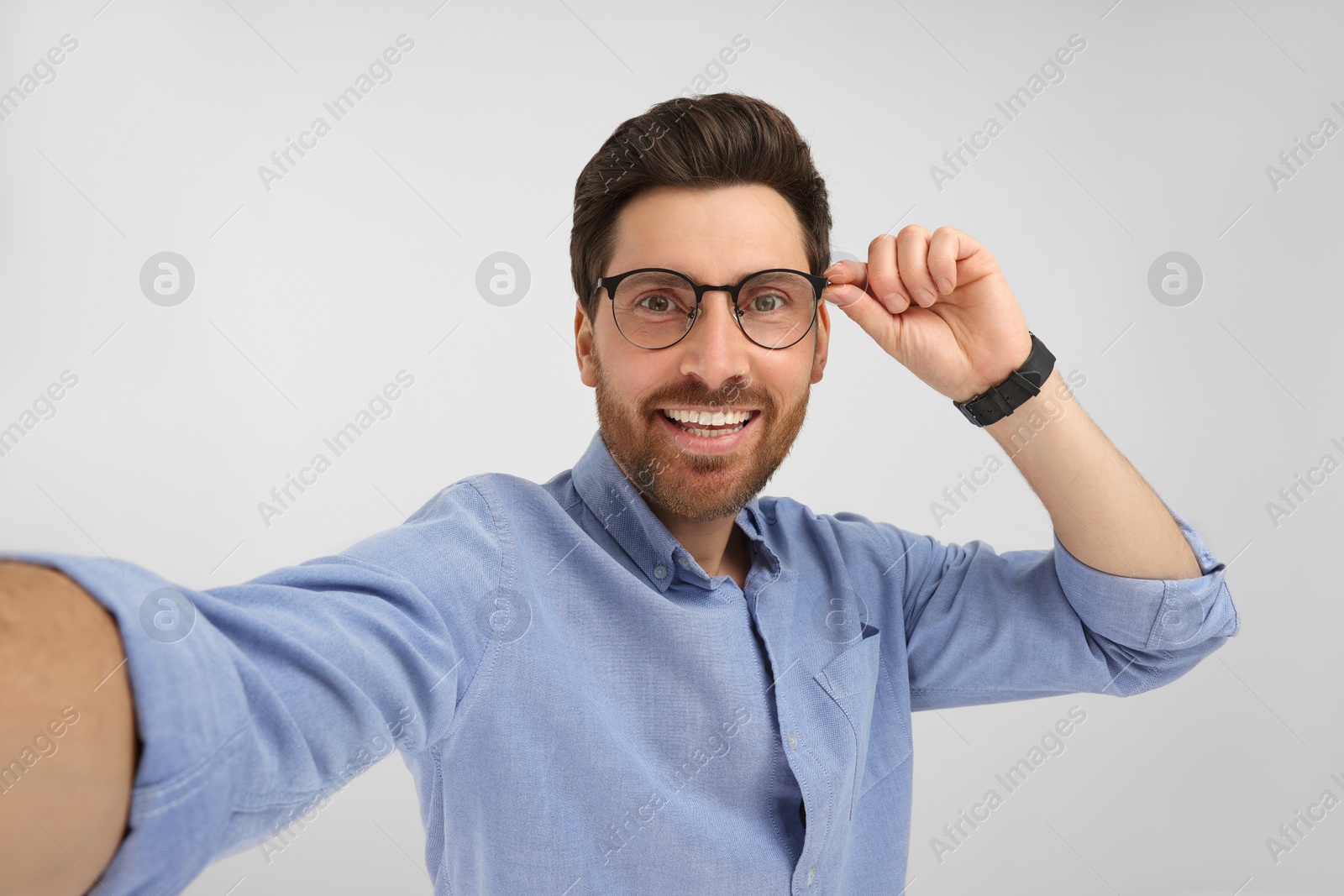 Photo of Smiling man taking selfie on white background