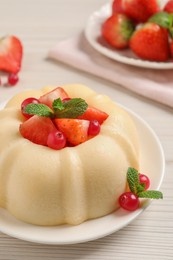 Delicious semolina pudding with berries on white wooden table