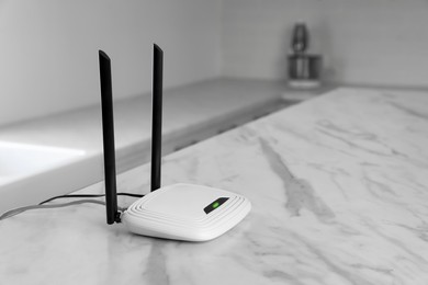 Photo of Modern Wi-Fi router on table indoors. Space for text