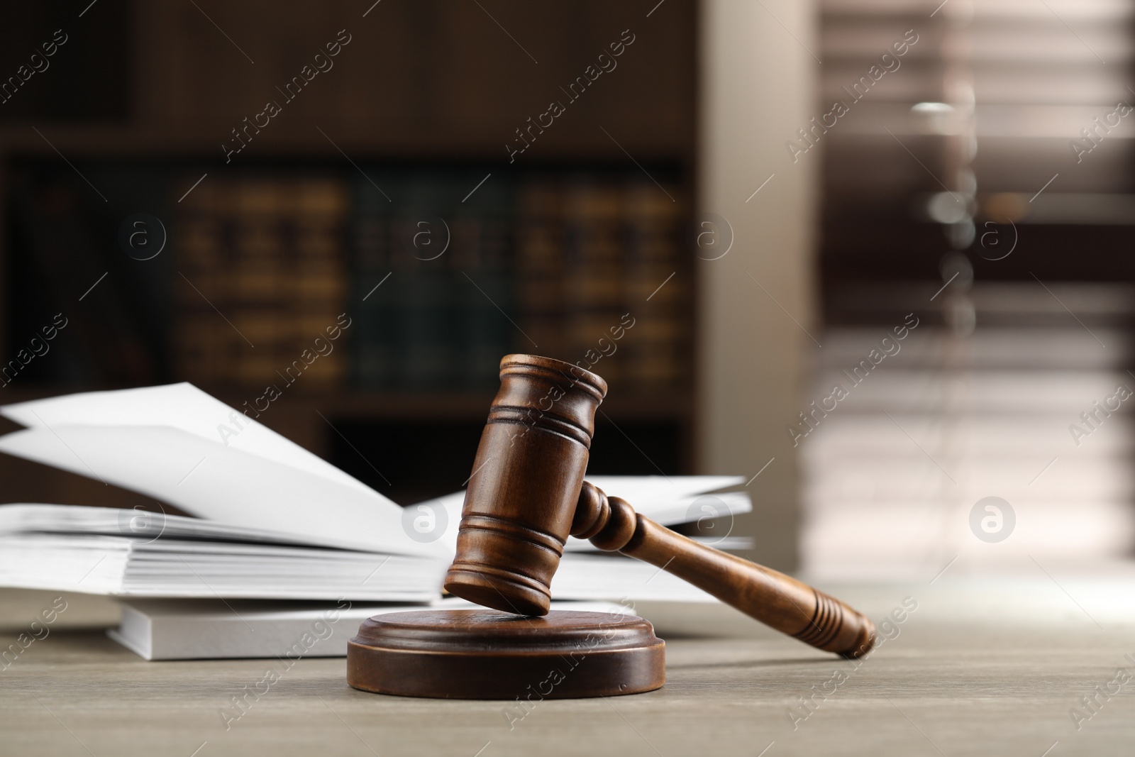 Photo of Wooden gavel and books on table indoors