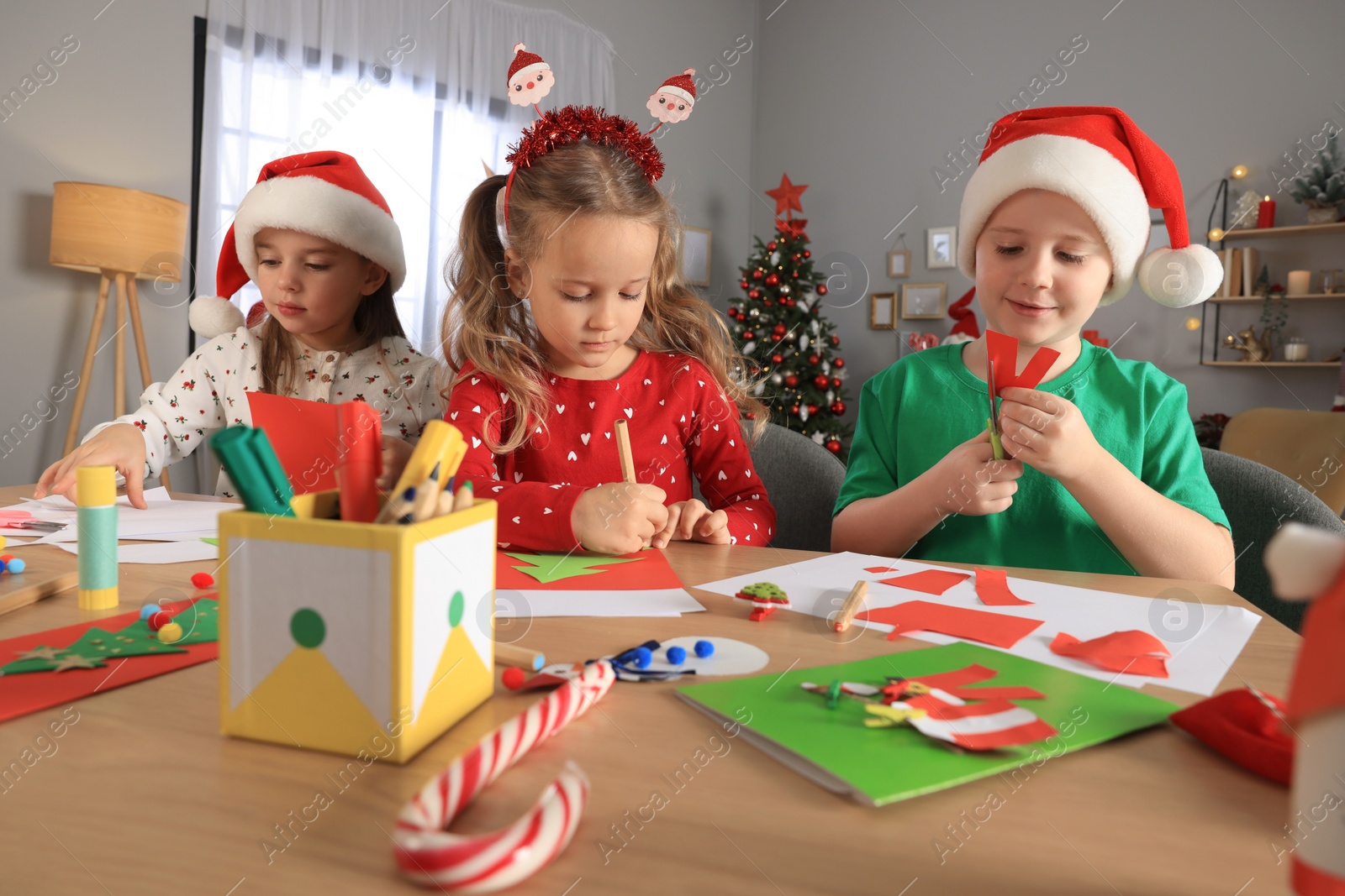 Photo of Cute little children making beautiful Christmas greeting cards at home