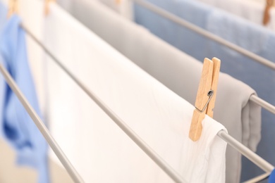 Clean laundry hanging on drying rack, closeup