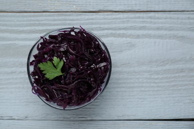 Photo of Tasty red cabbage sauerkraut with parsley on light grey wooden table, top view. Space for text