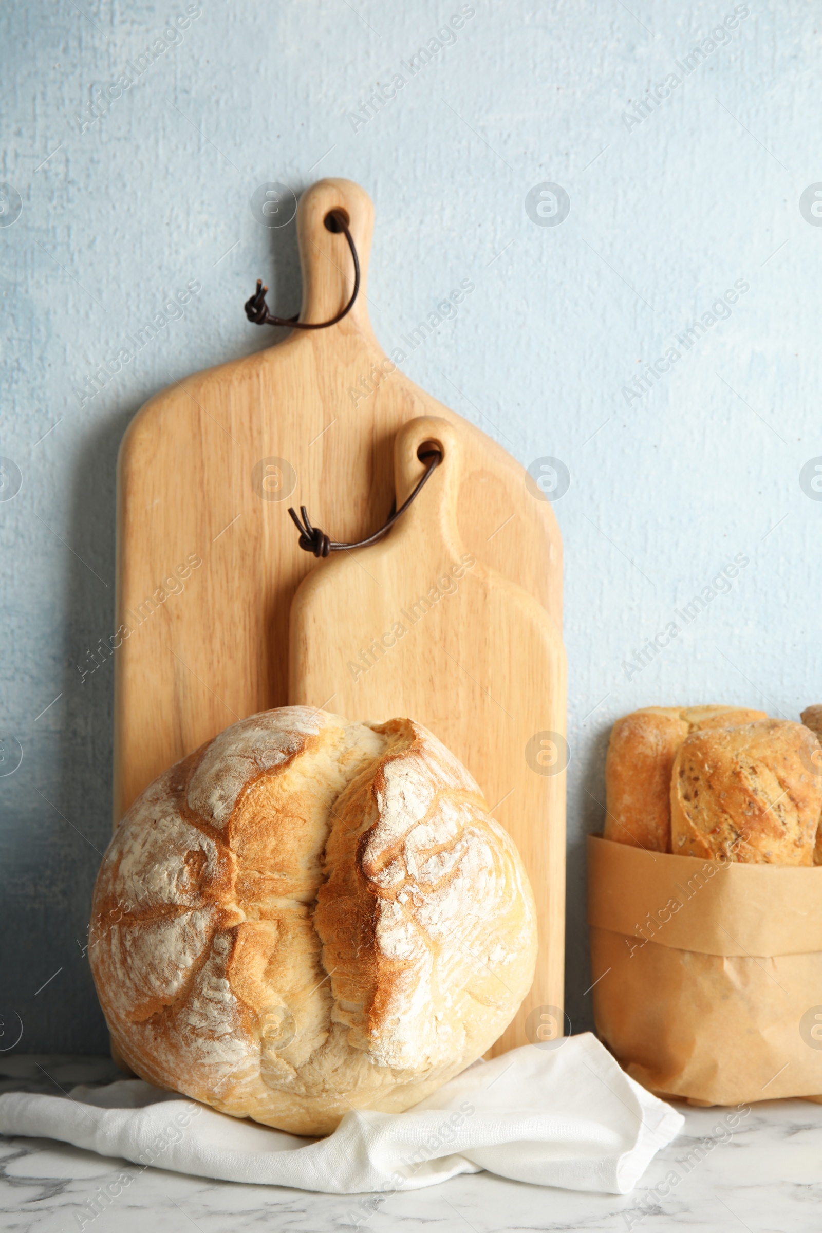 Photo of Composition with fresh bread on table near color wall