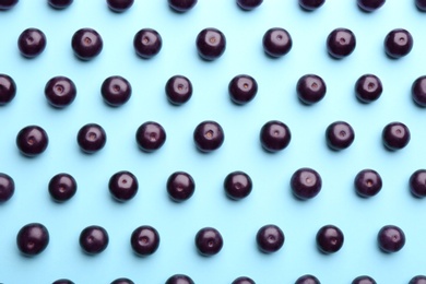 Fresh acai berries on light blue background, flat lay