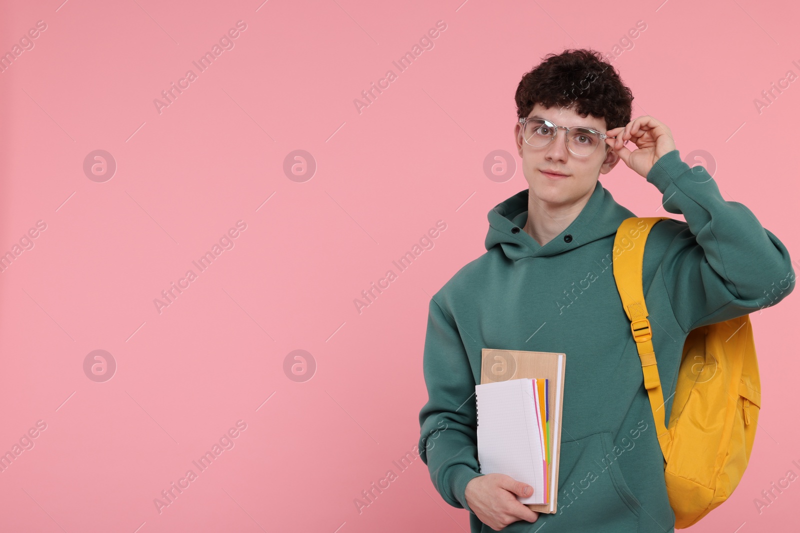 Photo of Portrait of student with backpack and notebooks on pink background. Space for text