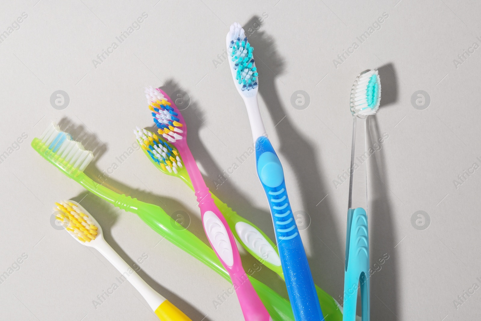 Photo of Many different toothbrushes on light background, flat lay