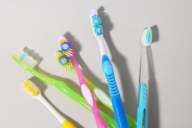 Photo of Many different toothbrushes on light background, flat lay