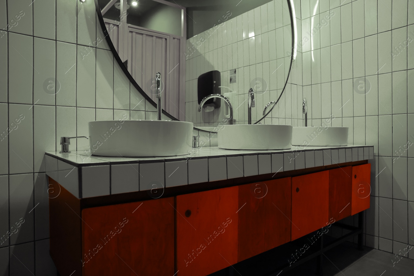 Photo of Public toilet interior with sinks and mirror