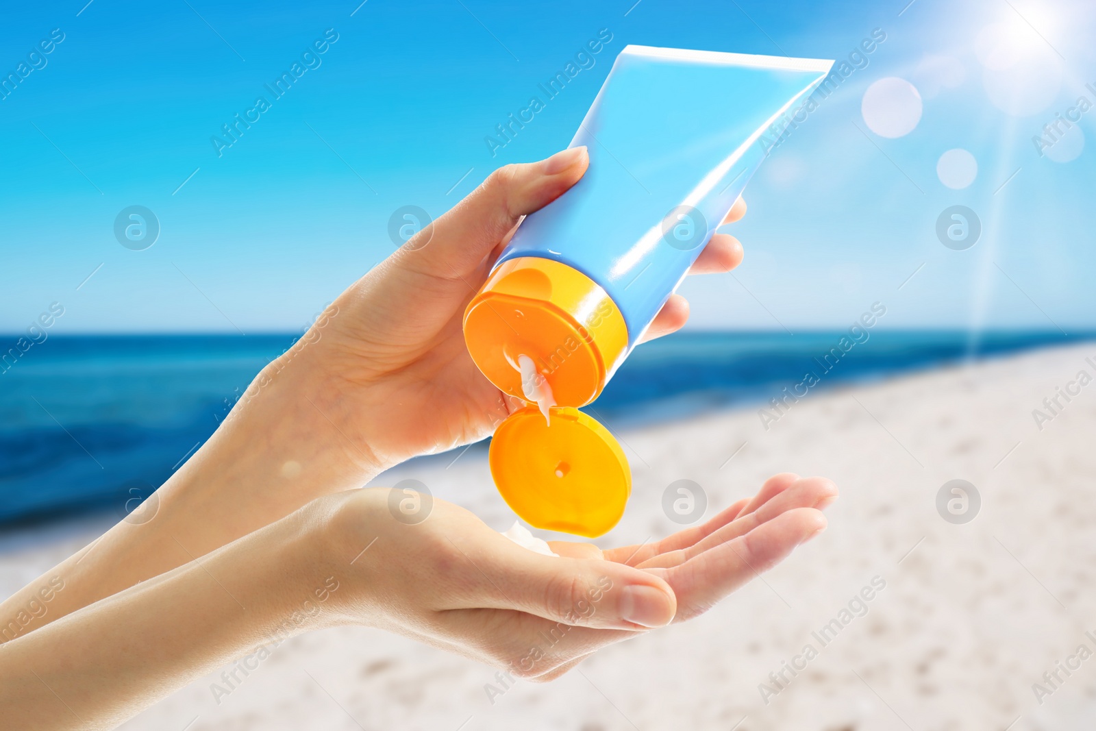 Image of Young woman applying sun protection cream near sea, closeup