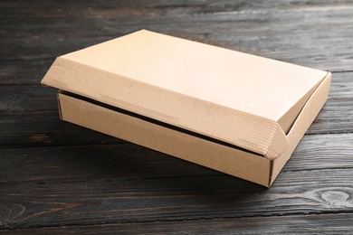 Photo of Open cardboard box on black wooden table