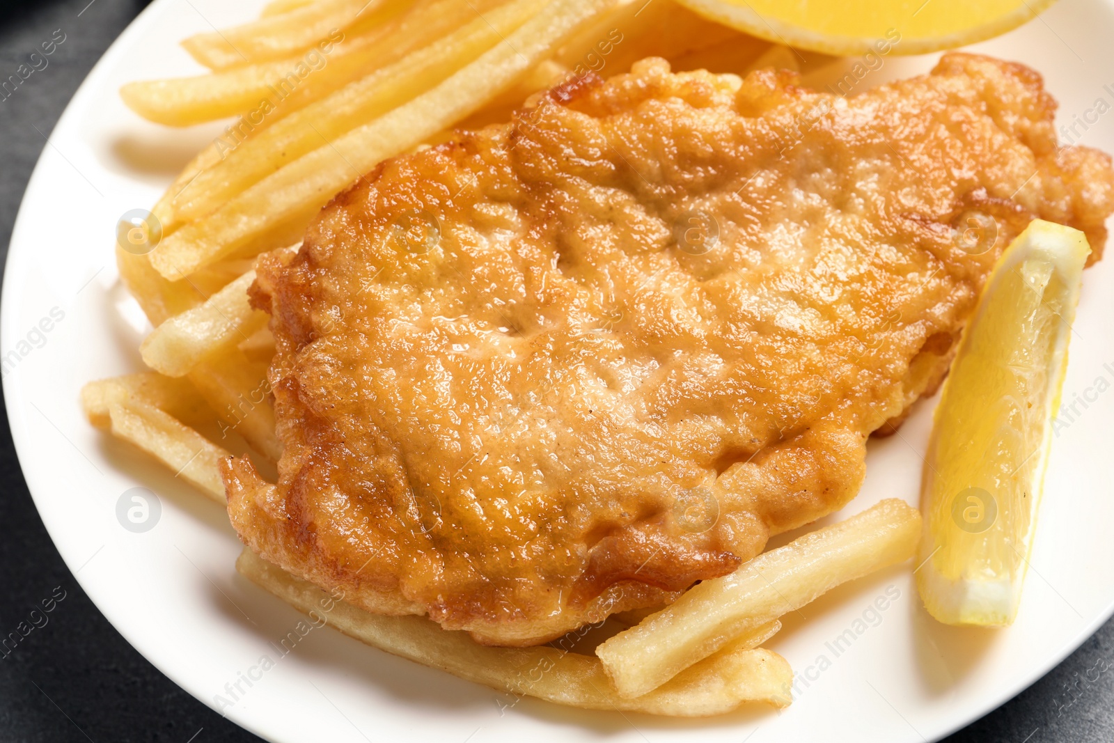 Photo of Plate with British traditional fish and potato chips, closeup