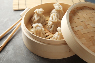 Bamboo steamer with tasty baozi dumplings on table