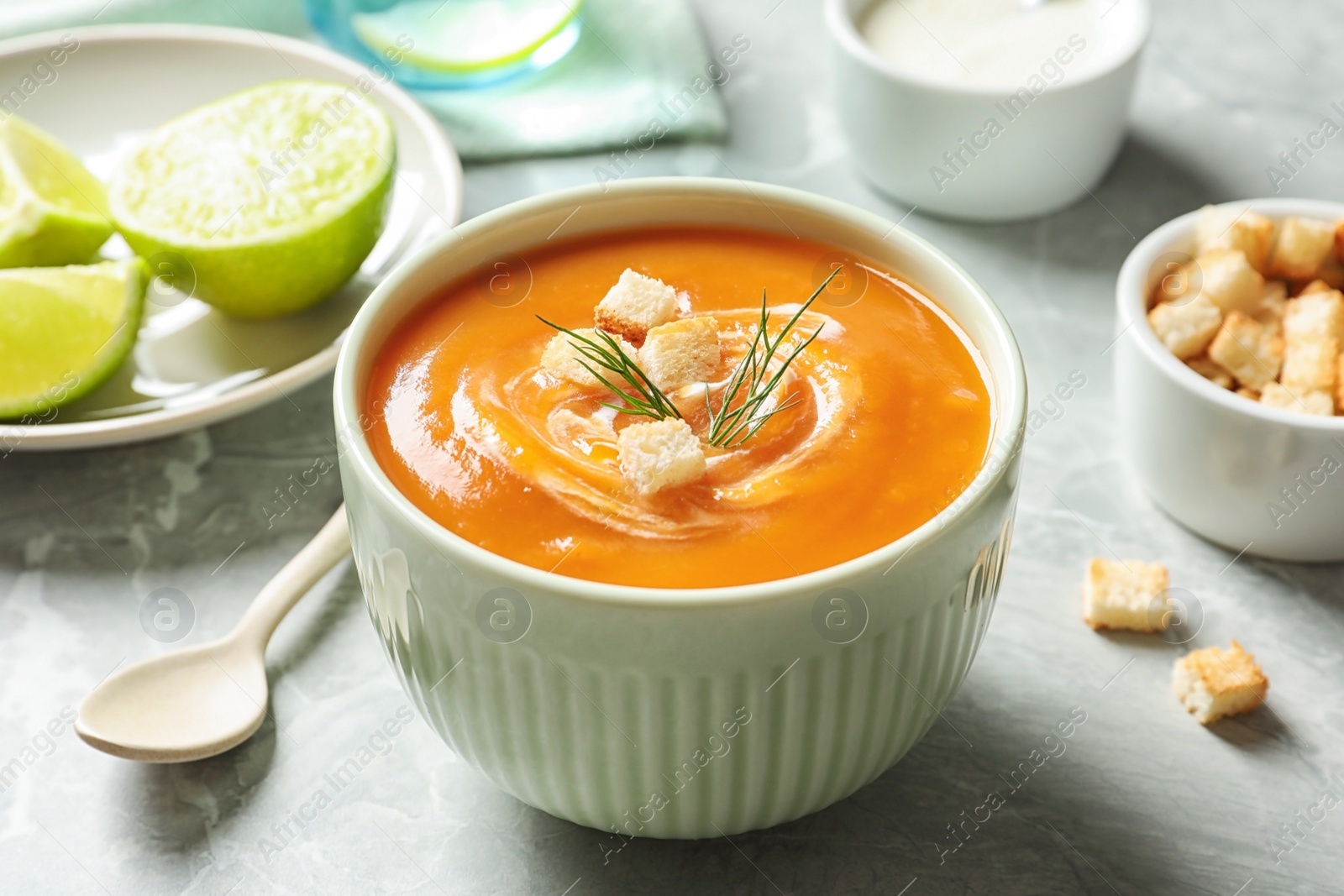 Photo of Bowl of tasty sweet potato soup served on table