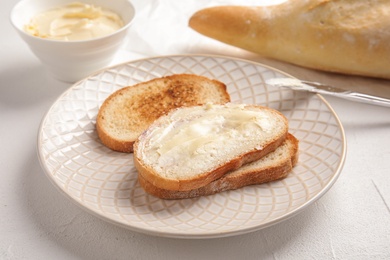 Photo of Tasty bread with butter for breakfast on plate