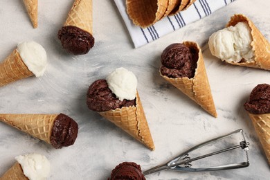 Flat lay composition with tasty ice cream scoops in waffle cones on light textured table