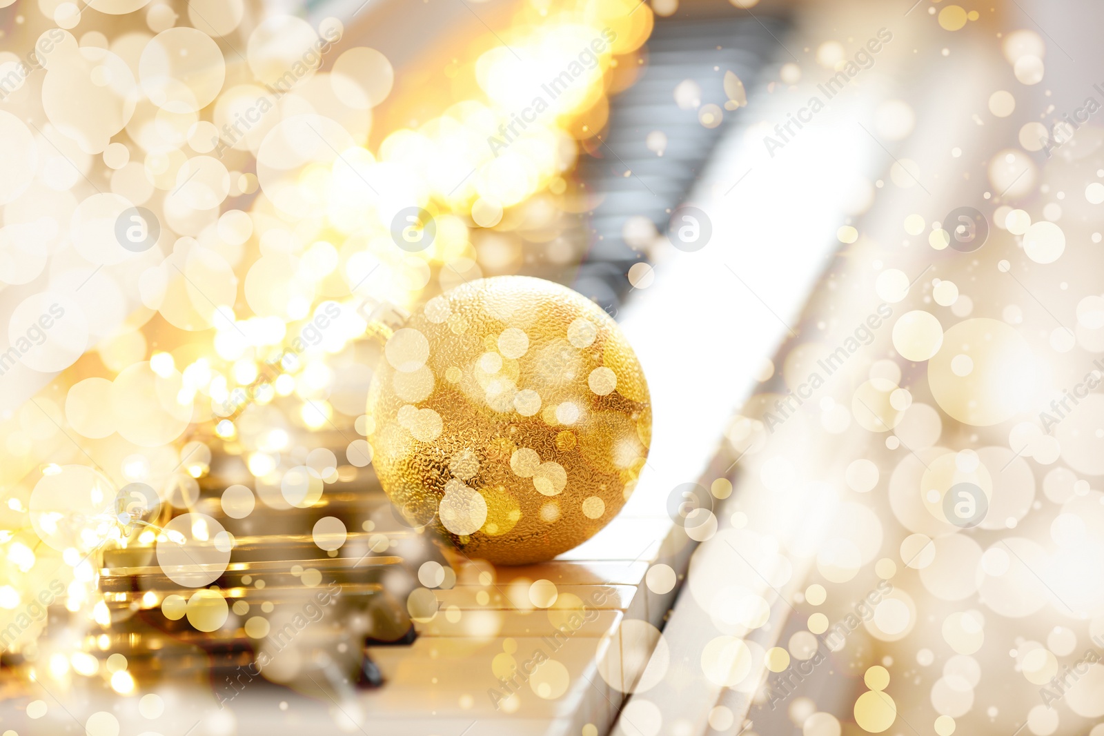 Image of Christmas and New Year music. Piano with festive ball, bokeh effect