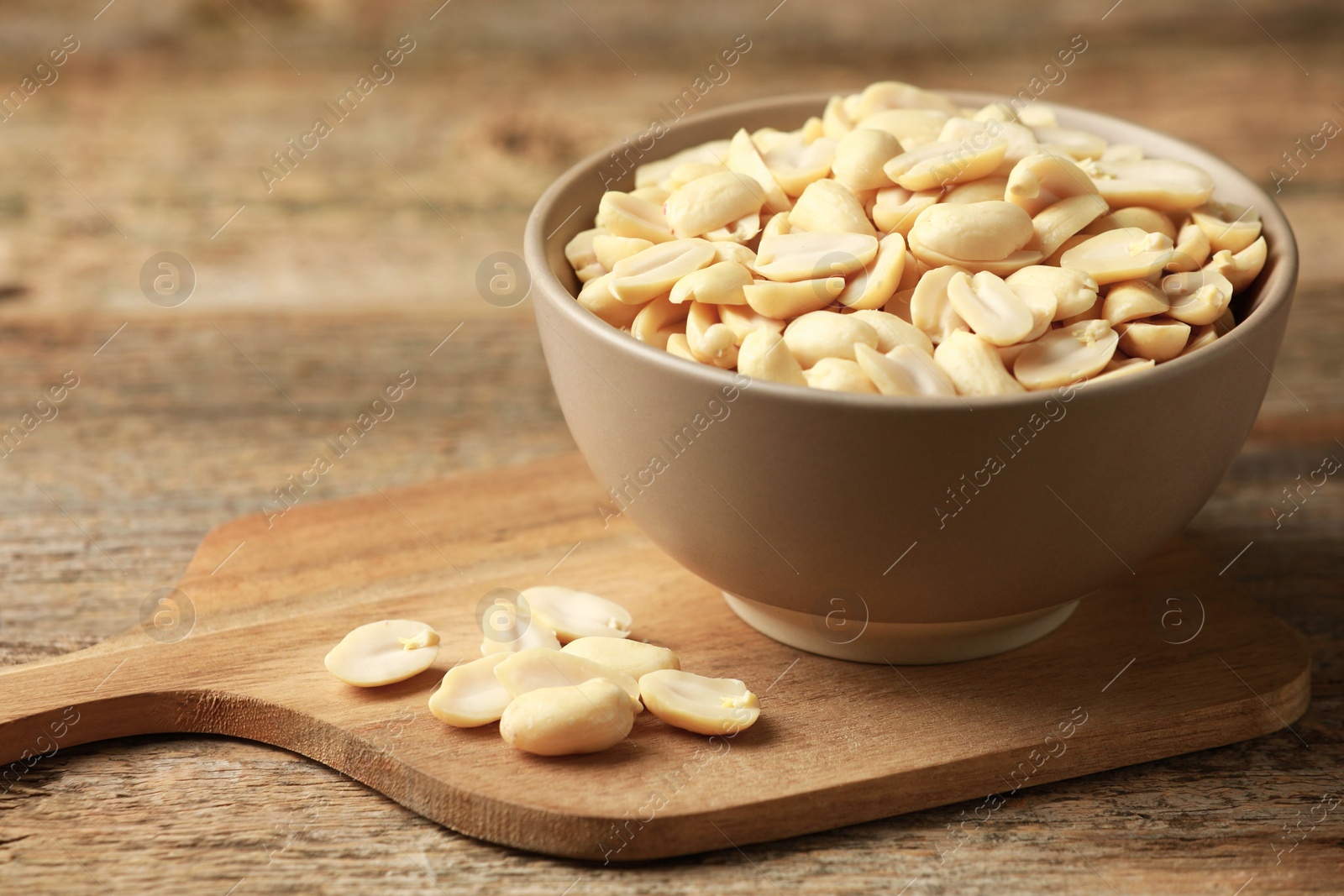 Photo of Fresh peanuts in bowl on wooden table