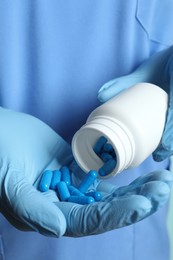 Photo of Doctor pouring pills from bottle onto hand, closeup view