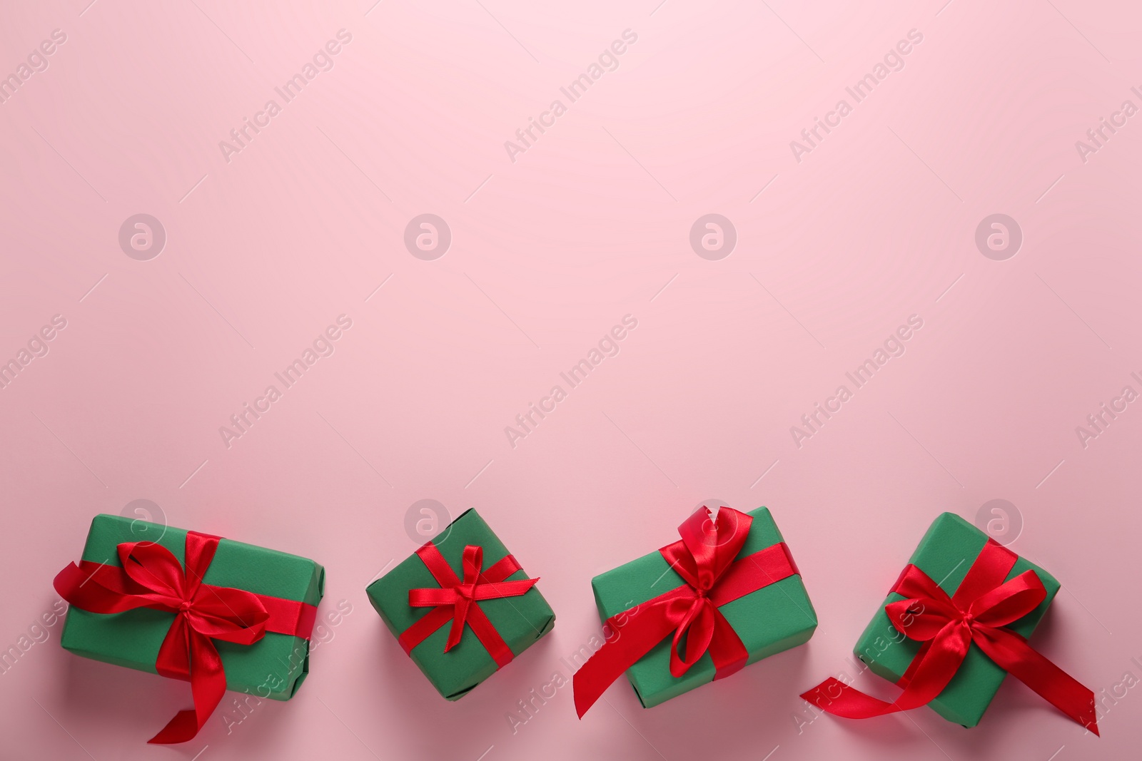 Photo of Bright gift boxes on pink background, flat lay. Space for text