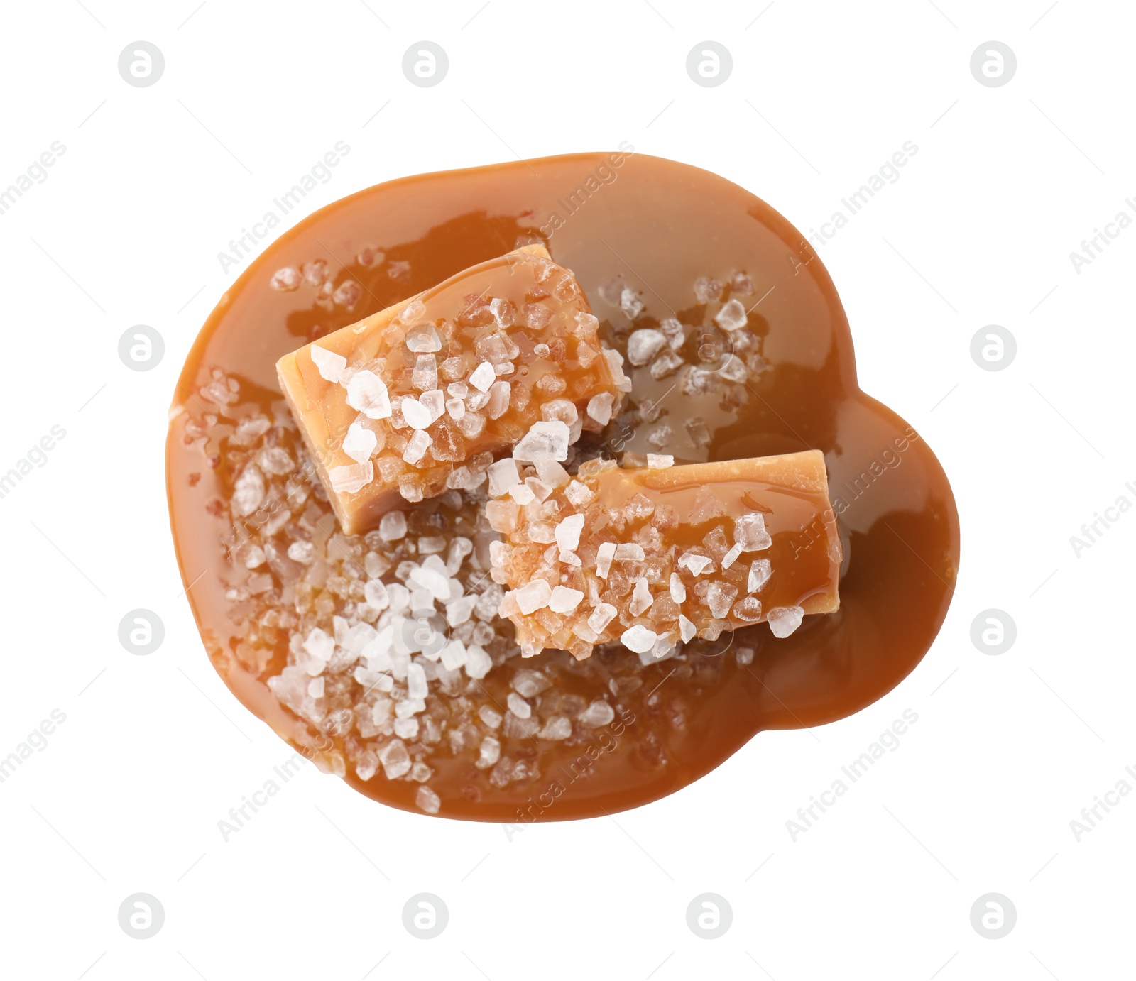 Photo of Yummy candies with caramel sauce and sea salt isolated on white, top view