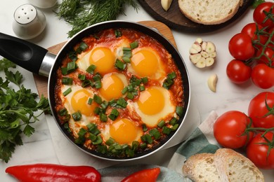 Photo of Flat lay composition with delicious shakshuka in frying pan on white table
