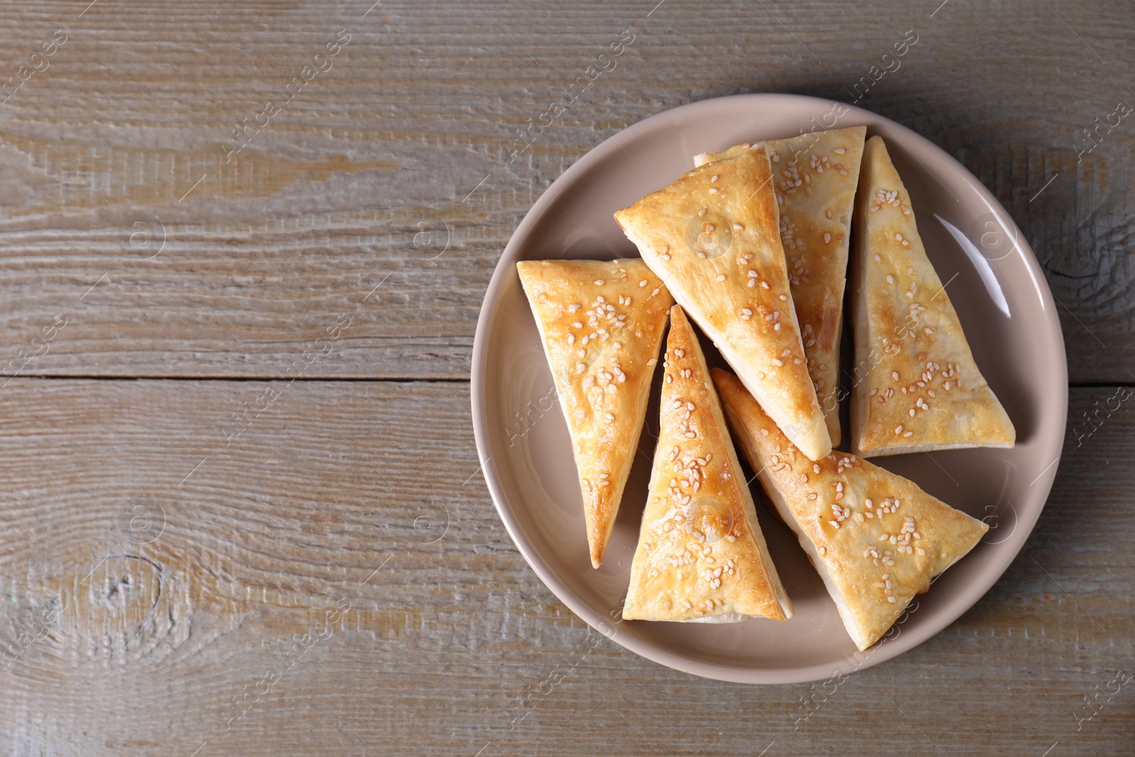 Photo of Delicious fresh puff pastries on wooden table, top view. Space for text