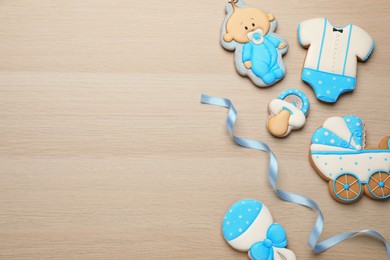 Photo of Cute tasty cookies of different shapes and space for text on white wooden table, flat lay. Baby shower party