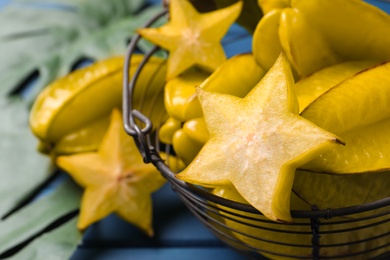 Delicious carambola fruits on blue table, closeup