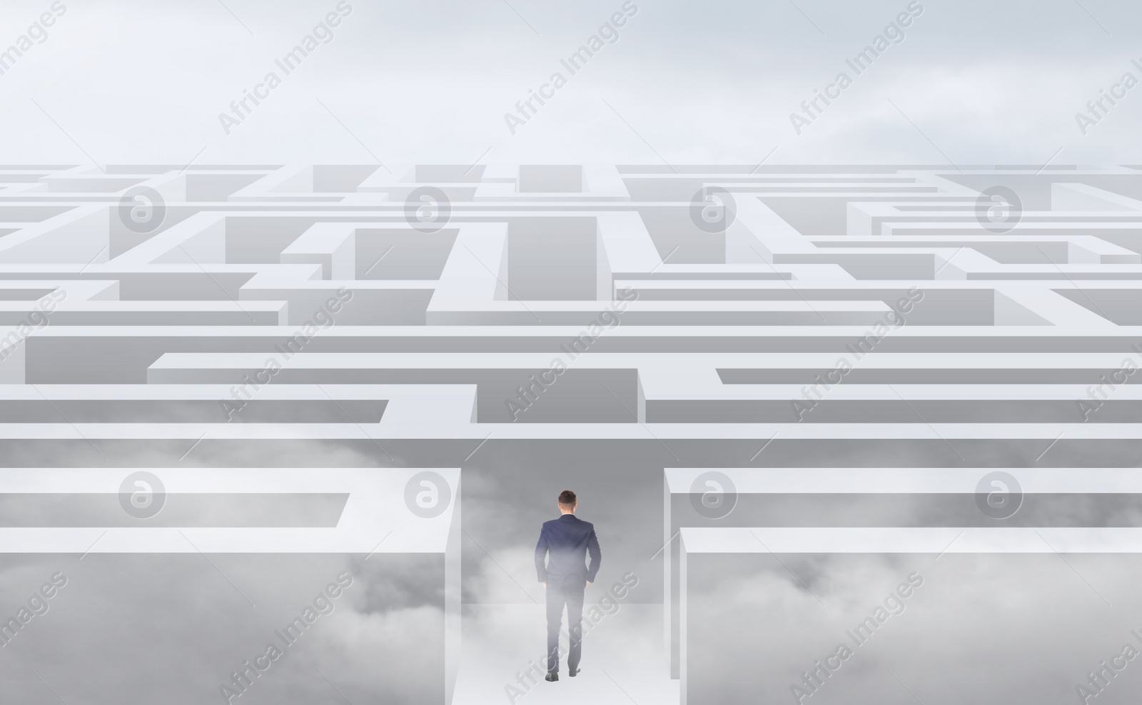 Image of Young businessman in suit trying to find way out of maze