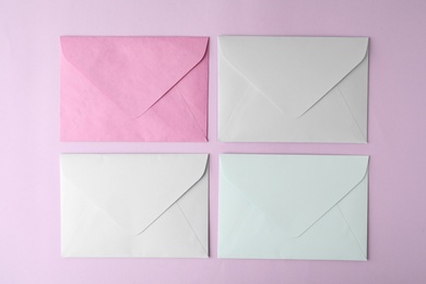 Colorful paper envelopes on pink background, flat lay