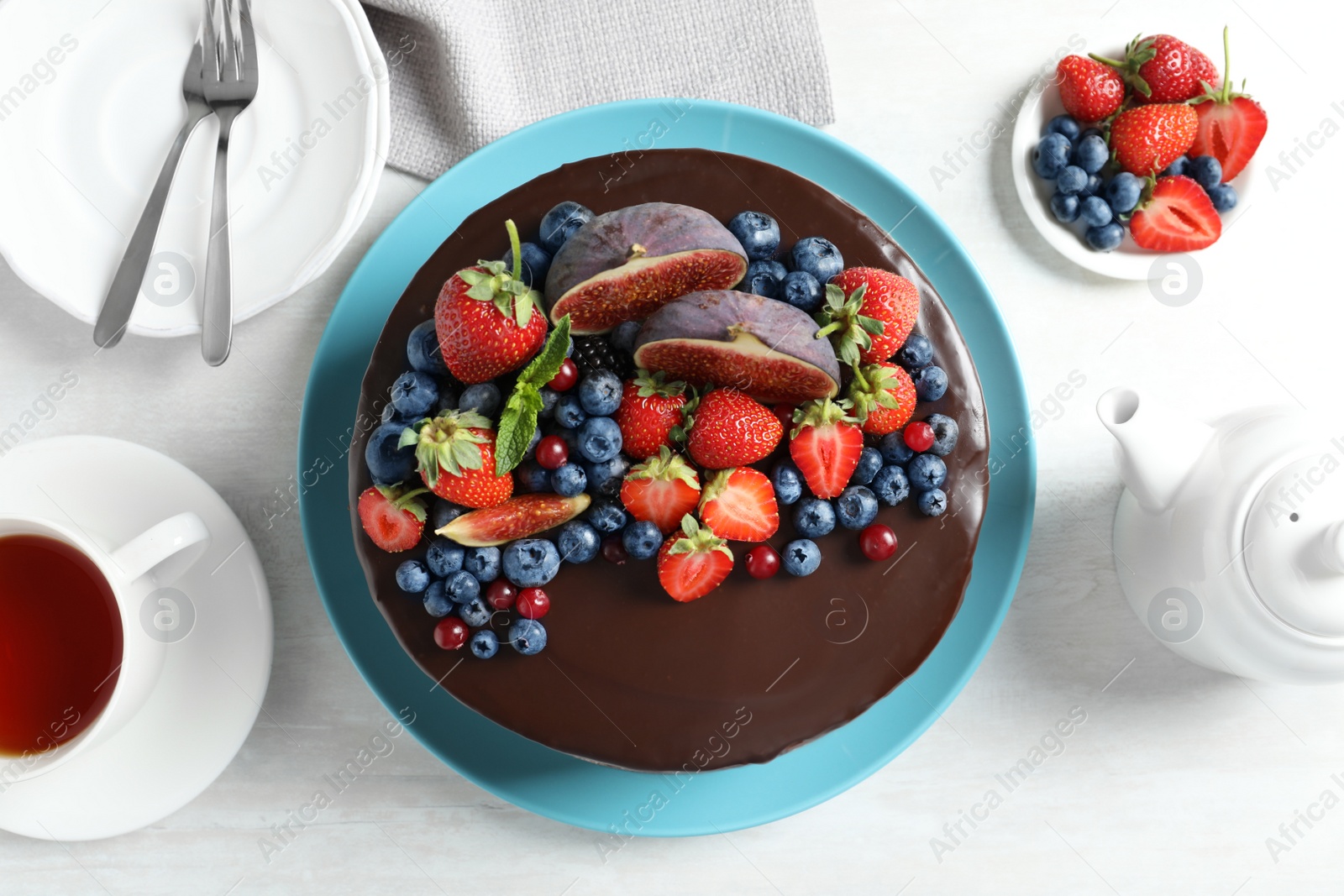 Photo of Fresh delicious homemade chocolate cake with berries on light table, flat lay