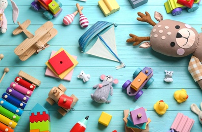Photo of Different toys on light blue wooden background, flat lay