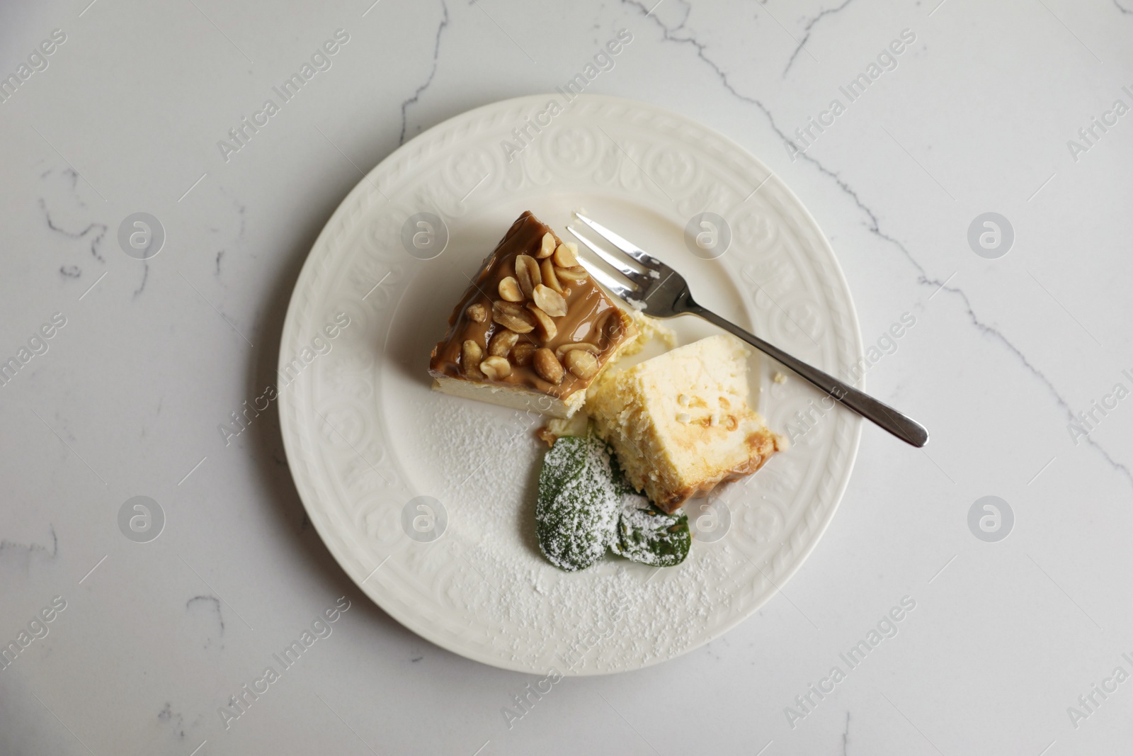 Photo of Tasty dessert and fork on white marble table, top view