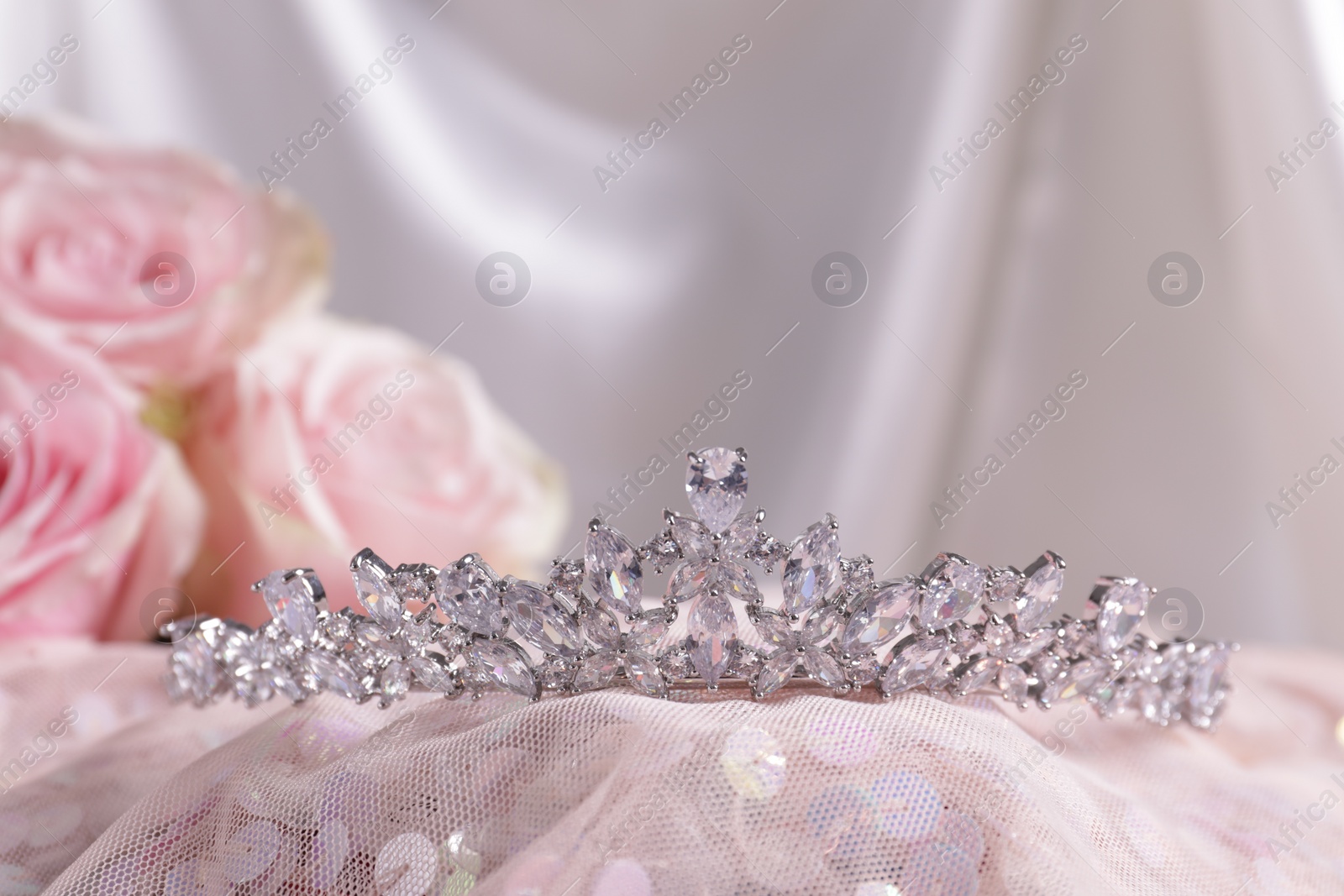 Photo of Beautiful silver tiara with diamonds on pink cloth