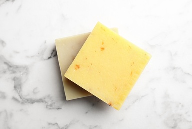 Photo of Hand made soap bars on marble background, top view