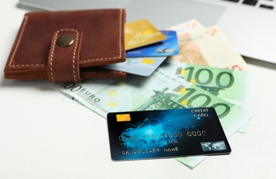 Photo of Credit cards, banknotes and wallet on white table